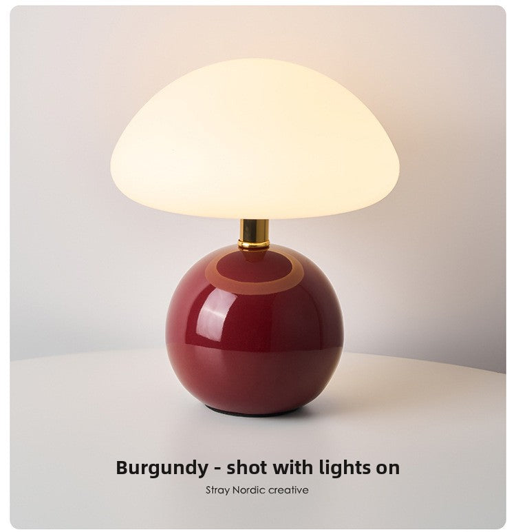 Mushroom table lamp in green colour on wooden desk